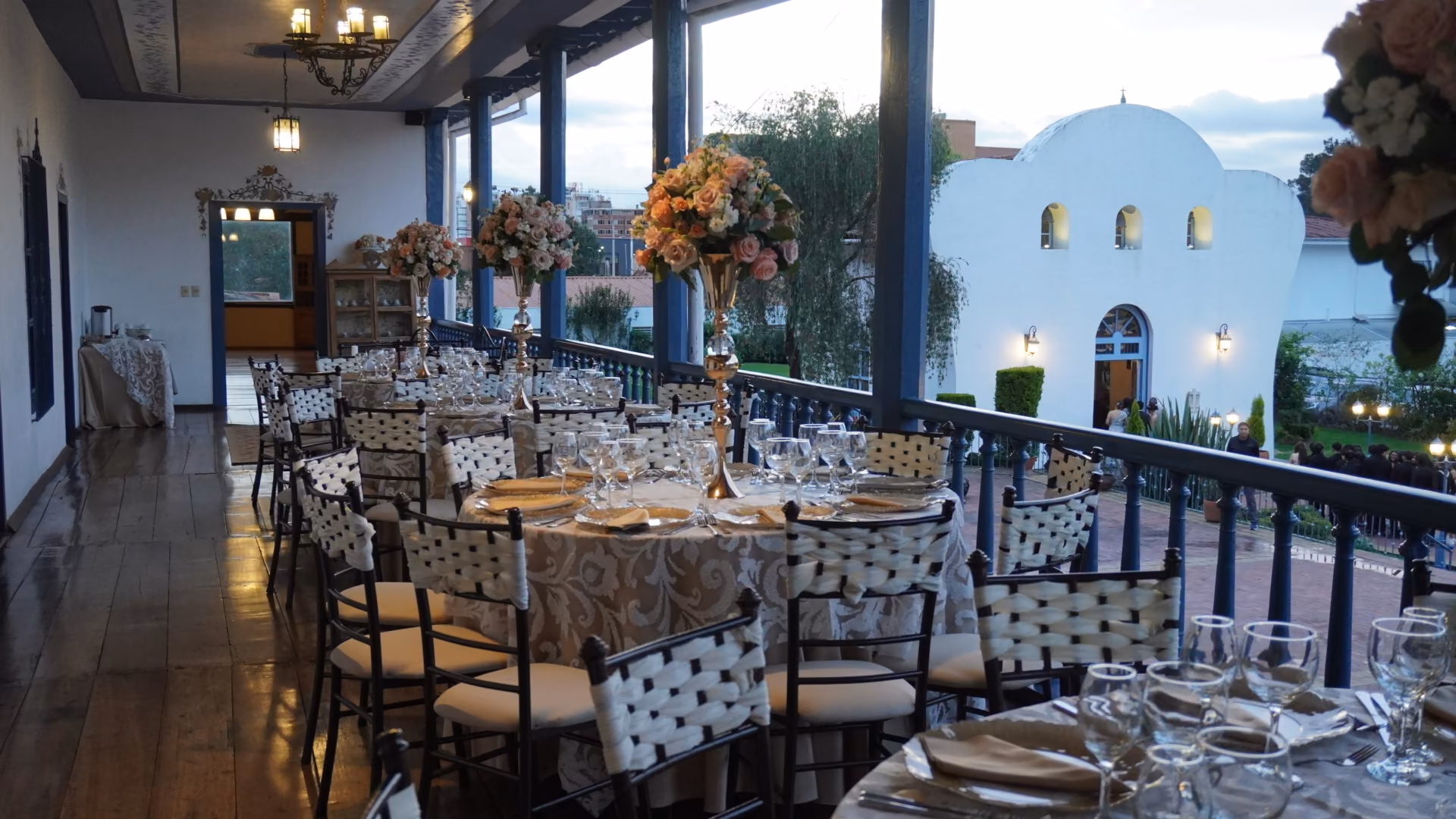 Tables dressed along the Casa Grande corridor, the chapel framed in the window.
